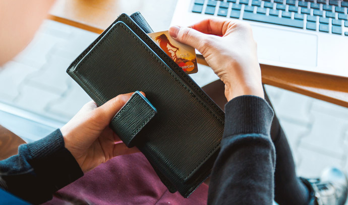 Hands removing a credit card from black wallet