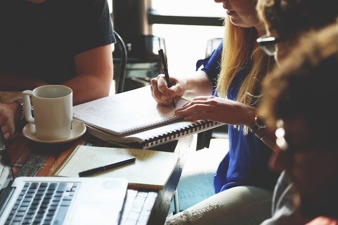 staff working at desk with notepad and paper